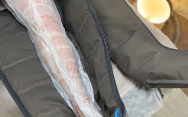 Presoterapijos batas ant klientės kojos procedūros metu